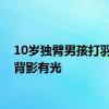 10岁独臂男孩打羽毛球背影有光